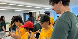 A volunteer helping a camper with a science experiment.